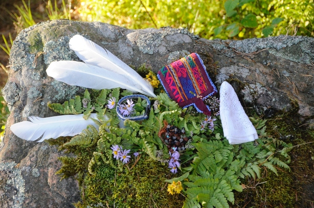 Indian accessories and feathers on stone with moss